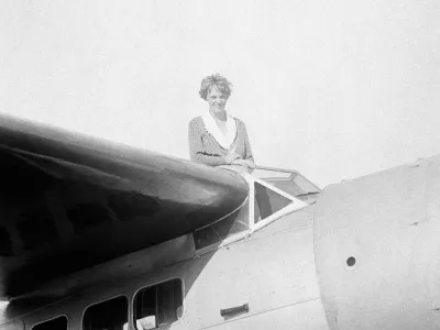FILE - In this undated photo, Amelia Earhart, the first woman to cross the Atlantic Ocean by plane sits on top of a plane. Secretary of State Hillary Rodham Clinton is wading into one of the 20th century's most enduring mysteries: the fate of American aviator Amelia Earhart, disappeared over the South Pacific 75 years ago. Clinton is meeting March 20, 2012, with historians and scientists from The International Group for Historic Aircraft Recovery, which will launch a new search in June for the wreckage of Earhart's plane off the remote island of Nikumaroro. (AP Photo)