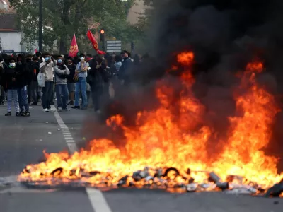 French high school and university students stand near burning garbage bins amid clashes during a protest to demand the hiring of substitute teachers, increased resources and better learning conditions, and to support the ongoing high-school student movement in the Seine-Saint-Denis department, in Saint-Denis near Paris, France, October 1, 2026. REUTERS/Abdul Saboor