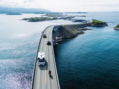 Travelers navigate the Atlantic Ocean Road, showcasing scenic landscapes and beautiful water views. Camper on the road in Norway