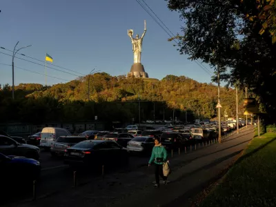 A woman walks near the Ukrainian Motherland Monument along a street that is clogged with cars headed to the left bank of the city, after Russian drone strikes on Kyiv's bridges caused disruptions, amid Russia's attack on Ukraine, in Kyiv, Ukraine October 2, 2026. REUTERS/Thomas Peter