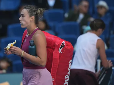 Aryna Sabalenka, of Belarus, left, leaves the court after lost in the third round of the women's singles match to Nikola Bartunkova, of the Czech Republic, at the China Open tennis tournament in Beijing, Sunday, Oct. 4, 2026. (AP Photo/Achmad Ibrahim)