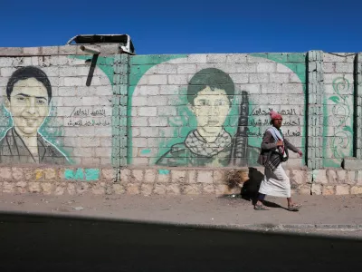 A man walks past murals of dead Houthi fighters on a wall in Sanaa, Yemen October 4, 2026. REUTERS/Stringer