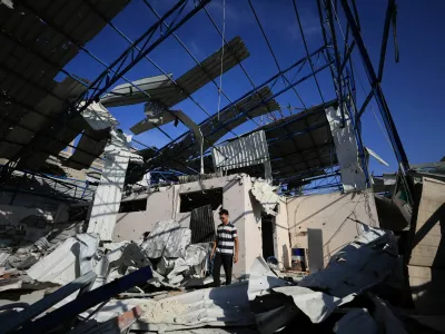 A Palestinian young man stands amid the debris of Al-Hassayna family's company warehouse, damaged during the war, in Gaza City, September 28, 2026. REUTERS/Dawoud Abu Alkas