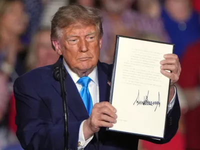 President Donald Trump holds a signed executive order at a campaign rally at the Pinnacle Bank Expo Center, Monday, Oct. 5, 2026, in Grand Island, Neb. (AP Photo/Charlie Riedel)