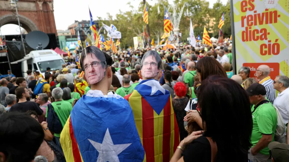 FILE PHOTO: People wear card board masks with the image of exiled Catalan separatist leader Carles Puigdemont during a demonstration on Catalonia's national day of 'La Diada' in Barcelona, Spain, September 11, 2024. REUTERS/Bruna Casas/File Photo