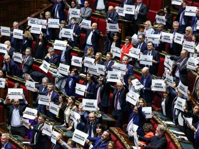 Members of parliament hold up signs at Italy's lower house of parliament on the day of a final vote on a contested electoral reform proposed by Prime Minister Giorgia Meloni, in Rome, Italy, October 8, 2026. REUTERS/Matteo Minnella   TPX IMAGES OF THE DAY