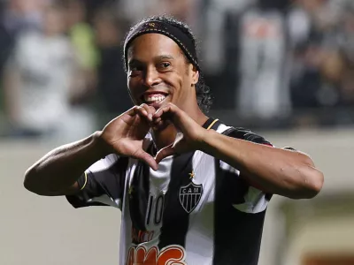 FILE - In this July 11, 2013 file photo, Brazil's Atletico Mineiro's Ronaldinho celebrates his team's victory over Argentina's Newell's Old Boys at the end of a Copa Libertadores semifinal soccer match in Belo Horizonte, Brazil. The brother and agent of 2005 Ballon d'Or winner Ronaldinho says the former Brazil and Barcelona playmaker has retired from football. (AP Photo/Bruno Magalhaes, File)