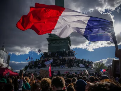 A person holds a French national flag during a protest against under-resourced schools in Paris, Thursday, Oct. 8, 2026. (AP Photo/Aurelien Morissard)