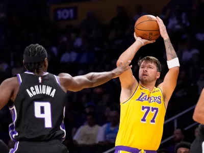 Los Angeles Lakers forward/guard Luka Dončić, right, shoots as Sacramento Kings forward Precious Achiuwa defends during the first half of a preseason NBA basketball game Thursday, Oct 8, 2026, in Los Angeles. (AP Photo/Mark J. Terrill)