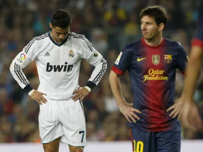 Barcelona's Lionel Messi (R) walks past Real Madrid's Cristiano Ronaldo during their Spanish first division soccer match at Nou Camp stadium in Barcelona, October 7, 2012.  REUTERS/Albert Gea (SPAIN - Tags: SPORT SOCCER)