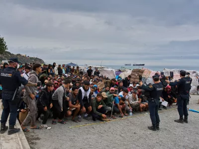 Migrants wait for food distribution to begin on El Trampol&iacute;n Beach in the Spanish enclave of Ceuta, Monday, Sept. 28, 2026. (AP Photo/Bernat Armangue)