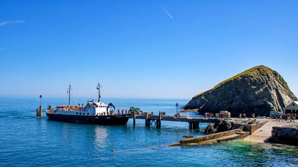 The MS Oldenburg docks at the jetty in Lundy Island bringing visitors and cargo to the shore.