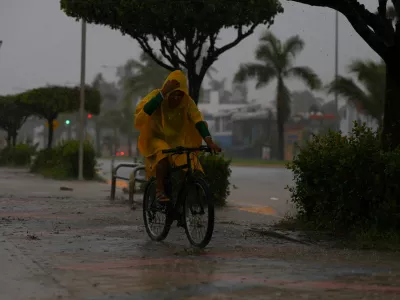 A man rides a bicycle as Hurricane Simon approaches Mexico's Pacific coast, bringing heavy rain and strong winds to Manzanillo, Mexico, October 11, 2026. REUTERS/Daniel Becerril