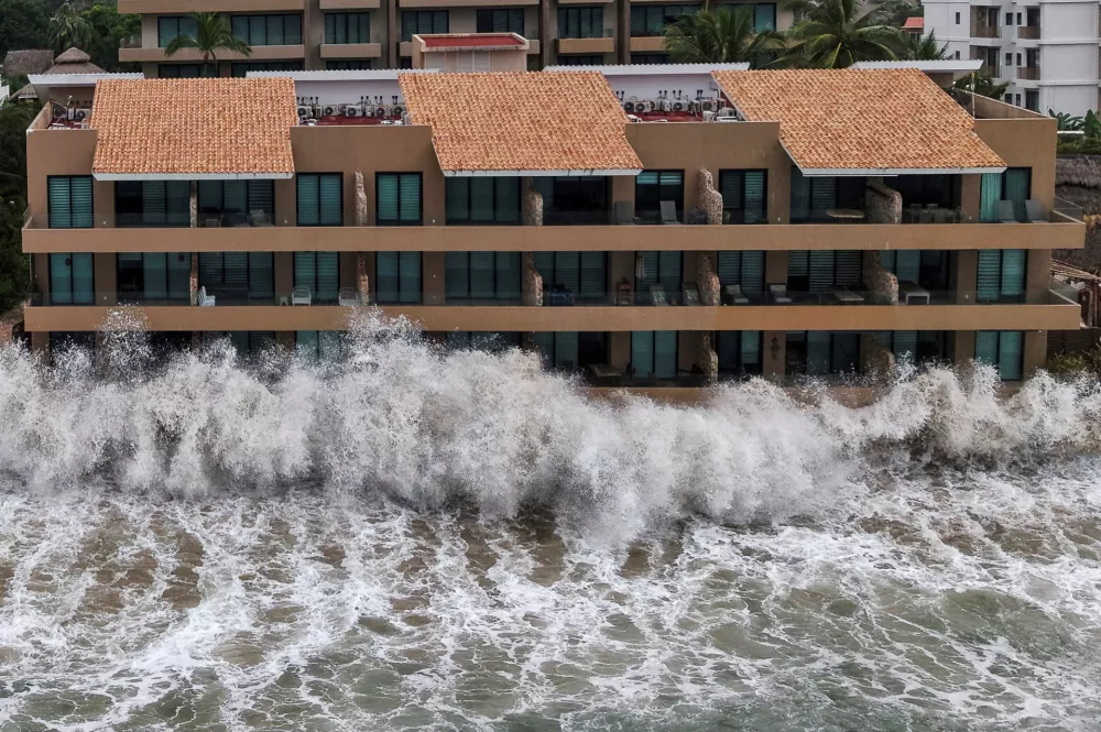 A drone view shows waves crashing against beachfront buildings as Hurricane Simon remains off Mexico's Pacific coast, in San Francisco, Bahia de Banderas, Nayarit state, Mexico, October 12, 2026. REUTERS/Christian Ruano
