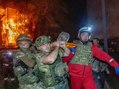 Rescuers evacuate an injured civilian after a residential building was hit following a Russian air attack in Kharkiv, Ukraine, Tuesday, Oct. 13, 2026. (AP Photo/Andrii Marienko)