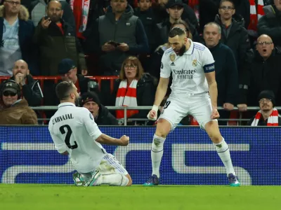 Soccer Football - Champions League - Round of 16 First Leg - Liverpool v Real Madrid - Anfield, Liverpool, Britain - February 21, 2023 Real Madrid's Karim Benzema celebrates scoring their fourth goal with Dani Carvajal REUTERS/Phil Noble
