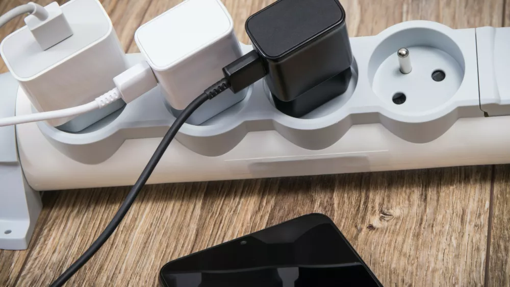 Smartphone, mobile phone and chargers connected to electrical power strip. Various devices charging concept. Smartphone and chargers connected to electrical power strip. Various devices charging concept,Image: 1129613115, License: Royalty-free, Restrictions:, Model Release: no 