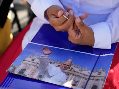 A nun holds a picture of Pope Leo XIV as she prays prior to the start of a Mass to conclude the Vatican meeting of the heads of Eastern Catholic Churches and presidents of bishops' conferences titled "Ten Years After Amoris Laetitia: Proclaiming the Gospel With Families Today," in St. Peter's Square, at the Vatican, Wednesday, Oct. 14, 2026. (AP Photo/Gregorio Borgia)