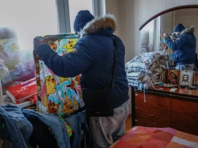 FILE PHOTO: Denys Davydenko, 40, hangs wet laundry at his family apartment, which has no heating or hot water and faces frequent power outages amid Russia's attack on Ukraine, in Kyiv, Ukraine, February 2, 2026. Waves of Russian attacks over the past four months left hundreds of thousands without electricity and water, making this the most devastating winter since the war started; and so the Davydenko family made the choice to stay at the family-owned Piggy Cafe Kyiv - with power supplied by a generator and heating. "Maksym likes it," Denys joked about their new reality. "He actually says that at home we have to do household chores. Now there's no dish-washing, cleaning, walking the dogs. So he is happy about that." REUTERS/Alina Smutko      SEARCH "SMUTKO COLD FAMILY" FOR THIS STORY. SEARCH "WIDER IMAGE" FOR ALL STORIES./File Photo