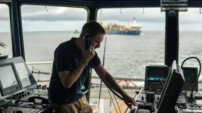 Deck navigation officer on the navigation bridge. He speaks by VHF radio, GMDSS Watchkeeping, collision prevention at sea. COLREG / Foto: Igor-kardasov