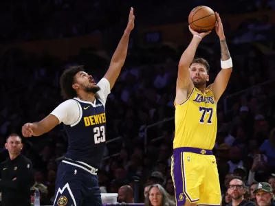 Los Angeles Lakers guard Luka Doncic (77) shoots over Denver Nuggets forward Cameron Johnson (23) during the first half of a preseason NBA basketball game Friday, Oct. 16, 2026, in Los Angeles. (AP Photo/Ben Liebenberg)