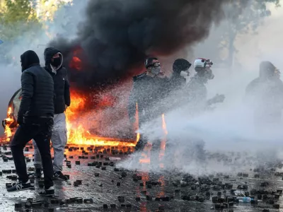 Protesters gather near a burning vehicle as a water cannon tries to spray them during an anti-government protest by students in Tirana, Albania, October 17, 2026. REUTERS/Louisa Gouliamaki