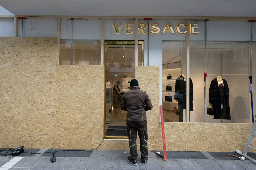Tradespeople are barricading the storefronts of luxury shops in downtown Frankfurt, Germany, Friday, Oct. 30, 2026, on the day before the planned large-scale "GEN-Z" demonstration. (Boris Roessler/dpa via AP) / Foto: Boris Roessler