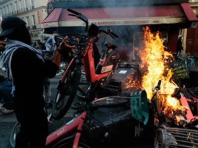 A man throws a bicycle onto a fire during a spontaneous protest, marked by riots and clashes with law enforcement, near Place de la Republique in Paris, Ile-de-France, France, on October 18, 2026. This gathering was a continuation of the national protest on October 17, 2026, against the high cost of living, bringing together, in particular, the Yellow Vests, high school students, college students, and various activist groups, following a day marked by significant unrest in several areas of the capital.Un homme jete un velo pour alimenter un feu lors manifestation sauvage, marquee par des emeutes et des affrontements avec les forces de l ordre, proche de la place de la Republique, a Paris, Ile de France, France, le 18 octobre 2026. Ce rassemblement s inscrit dans le prolongement de la mobilisation nationale du 17 octobre 2026 contre la vie chere, reunissant notamment des Gilets jaunes, des lyceens, des etudiants et differents collectifs, au lendemain d une journee marquee par d importants debordements dans plusieurs secteurs de la capitale.