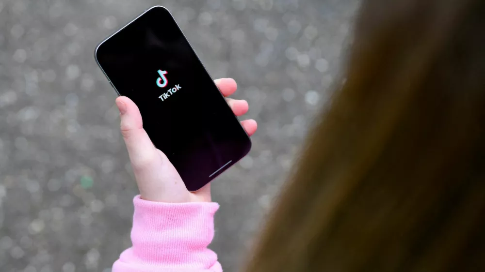 Dekle s telefonom v roki