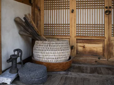 There are wooden baskets and wooden bowls on the floor of a Hanok house..