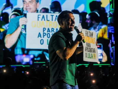 Presidential candidate Flavio Bolsonaro from the Liberal Party (PL) holds a placard reading "Four days left to retire Lula!!!", as he speaks on stage during a campaign event in Guarulhos, Brazil, October 21, 2026. REUTERS/Brian Snyder