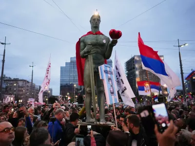 People hold a replica of the Serbian capital landmark The Victor or Pobednik statue during the final "Student List &ndash; Students Win" rally ahead of a parliamentary election in Belgrade, Serbia, Thursday, Oct. 22, 2026. (AP Photo/Petr David Josek)