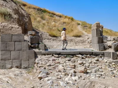 An archaeologist walk walks through the ruins of the fortress of Ayanis near Van, in eastern Turkey, on August 4, 2026. Although it emerged later than the great Mesopotamian kingdoms of Assyria, Sumer, and Babylon, Urartu succeeded in uniting the tribal communities of the Autoru Mountains into a centralized state, building fortresses, provincial capitals, irrigation networks, and vast storage facilities to support an agricultural economy.,Image: 1121981093, License: Rights-managed, Restrictions: Graphic ContentTO GO WITH AFP STORY BY ANNE CHAON, Model Release: no 