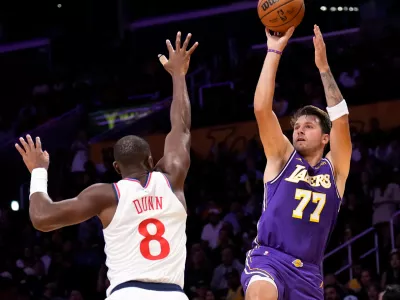 Los Angeles Lakers guard Luka Doncic, right, shoots as LA Clippers guard Kris Dunn defends during the first half of an NBA basketball game Friday, Oct. 23, 2026, in Los Angeles. (AP Photo/Mark J. Terrill)
