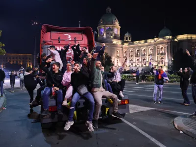People celebrate outside the National Assembly, after Aleksandar Vucic, leader of the right-wing Serbian Progressive Party (SNS) conceded defeat in the parliamentary election in Belgrade, Serbia, early Monday, Oct. 26, 2026. (AP Photo/Armin Durgut)