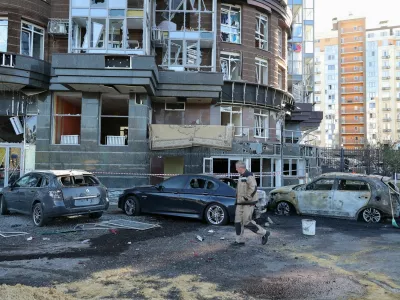 A man walks past damaged cars outside a residential complex hit by what local authorities described as a Ukrainian overnight drone strike, amid the Russia-Ukraine conflict, in central Belgorod, Russia, October 25, 2026. REUTERS/Stringer