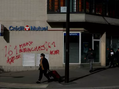 A woman walks past a vandalised Credit Mutuel store the day after clashes during a second day of nationwide protests against the cost of living and rising fuel prices, in Paris, October 25, 2026. REUTERS/Hannah McKay