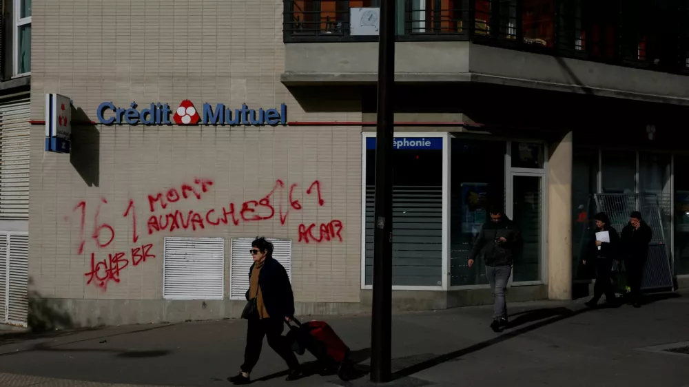 A woman walks past a vandalised Credit Mutuel store the day after clashes during a second day of nationwide protests against the cost of living and rising fuel prices, in Paris, October 25, 2026. REUTERS/Hannah McKay
