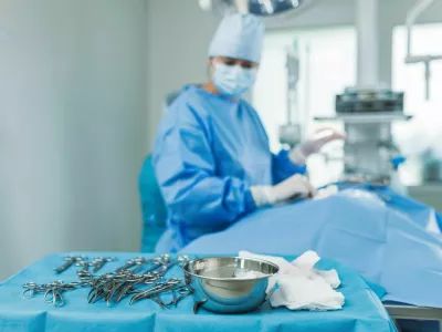A surgical team collaborates in a hospital OR, using professional equipment and sterile techniques for a procedure.