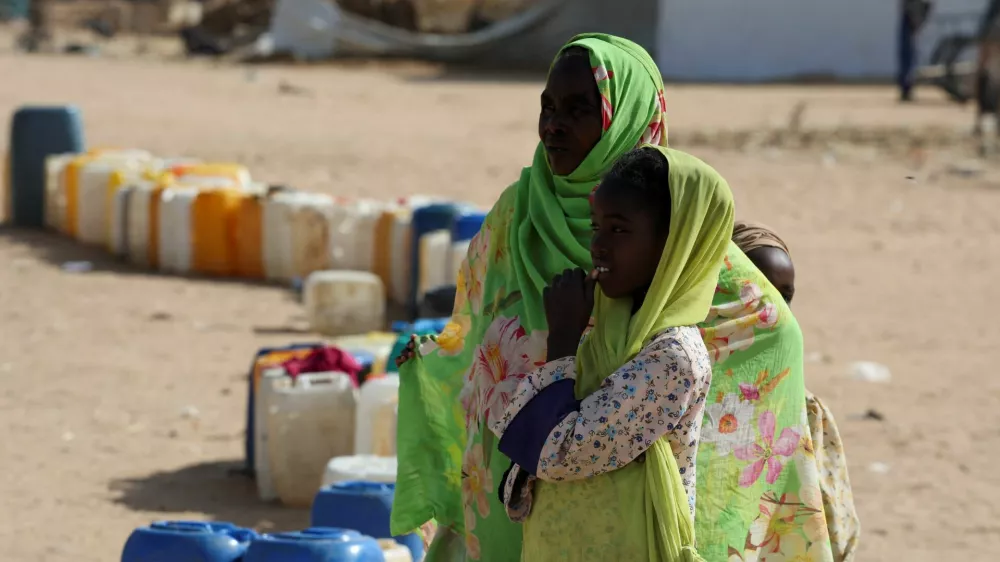 Sudanese refugee women react next to a line of empty jugs as families wait to collect water inside the Iridimi refugee camp, northwest of Iriba in Wadi Fira province, eastern Chad, November 27, 2025. REUTERS/Amr Abdallah Dalsh