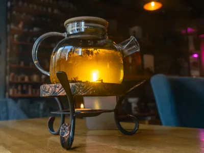 Golden hour tea ritual featuring herbal tea in a glass teapot symbolizing harmony warmth and shared moments of joy. Tranquil tea moment with herbal infusion in a clear teapot surrounded.
