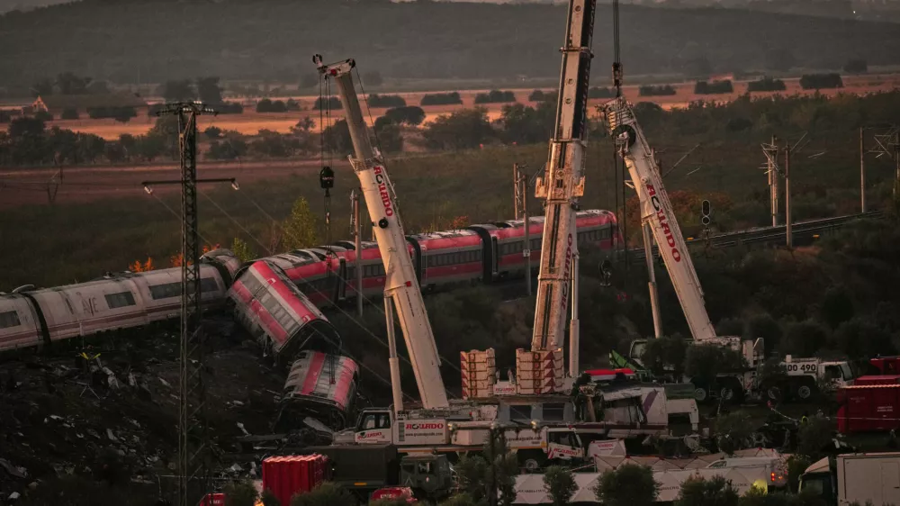 Cranes lift wrecked train carriages as rescuers search for victims following a collision between two trains in Urda, Spain, Thursday, Oct. 29, 2026. (AP Photo/Manu Fernandez)