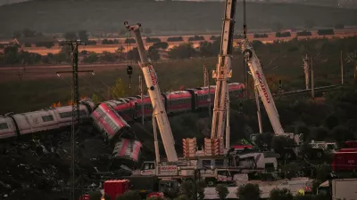 Cranes lift wrecked train carriages as rescuers search for victims following a collision between two trains in Urda, Spain, Thursday, Oct. 29, 2026. (AP Photo/Manu Fernandez)