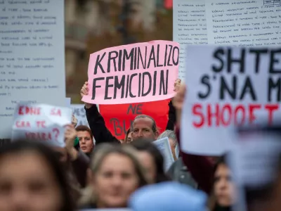 A man holds a sign "Criminalize Femicide" as thousands of people gather in Kosovo's capital to protest the killing of a Kosovo-American woman, Arlinda Zekaj, whose death sparked public outrage and renewed calls for accountability over violence against women in capital Pristina, Kosovo, on Wednesday, Oct.28, 2026. (AP Photo/Visar Kryeziu)