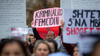 A man holds a sign "Criminalize Femicide" as thousands of people gather in Kosovo's capital to protest the killing of a Kosovo-American woman, Arlinda Zekaj, whose death sparked public outrage and renewed calls for accountability over violence against women in capital Pristina, Kosovo, on Wednesday, Oct.28, 2026. (AP Photo/Visar Kryeziu)