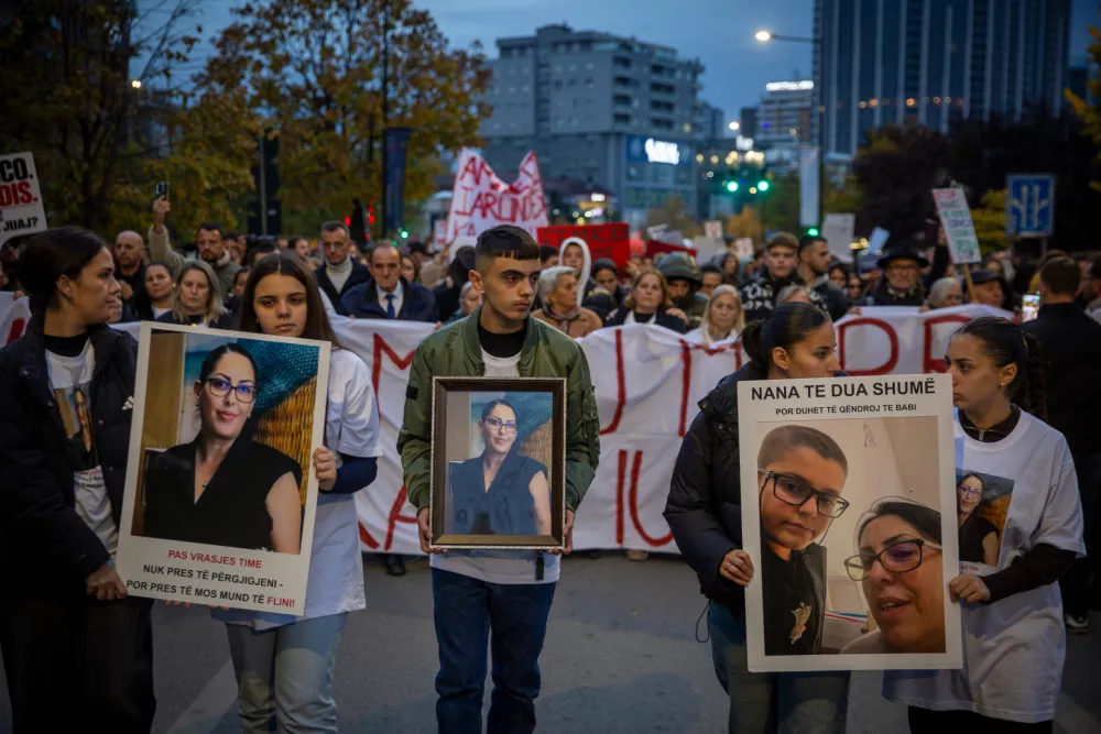 Family members of Arlinda Zekaj hold her picture during a protest in Pristina, Kosovo, as thousands gather to condemn the killing of the Kosovo-American woman, whose death sparked public outrage and renewed calls for accountability over violence against women, on Wednesday, Oct. 28, 2026. (AP Photo/Visar Kryeziu)