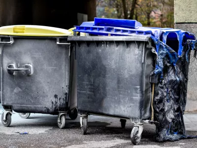 Burnt and melted trash can form a fire. Burned trash in waste container in the city is melted due to hot fire inside.