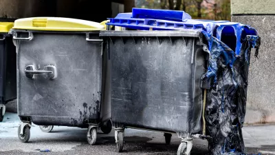 Burnt and melted trash can form a fire. Burned trash in waste container in the city is melted due to hot fire inside.