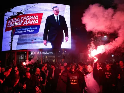 People celebrate after Aleksandar Vucic, leader of the right-wing Serbian Progressive Party (SNS), seen on the top display, conceded defeat in the parliamentary election in Belgrade, Serbia, Sunday, Oct. 25, 2026. (AP Photo/Armin Durgut)