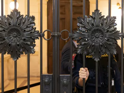An Austrian police officer waits outside the courtroom as the verdict for six men accused of providing various degrees of help to a jihadist who killed four people in a shooting rampage in Vienna in November 2020 is expected, in Vienna, Austria, February 1, 2023. REUTERS/Lisa Leutner